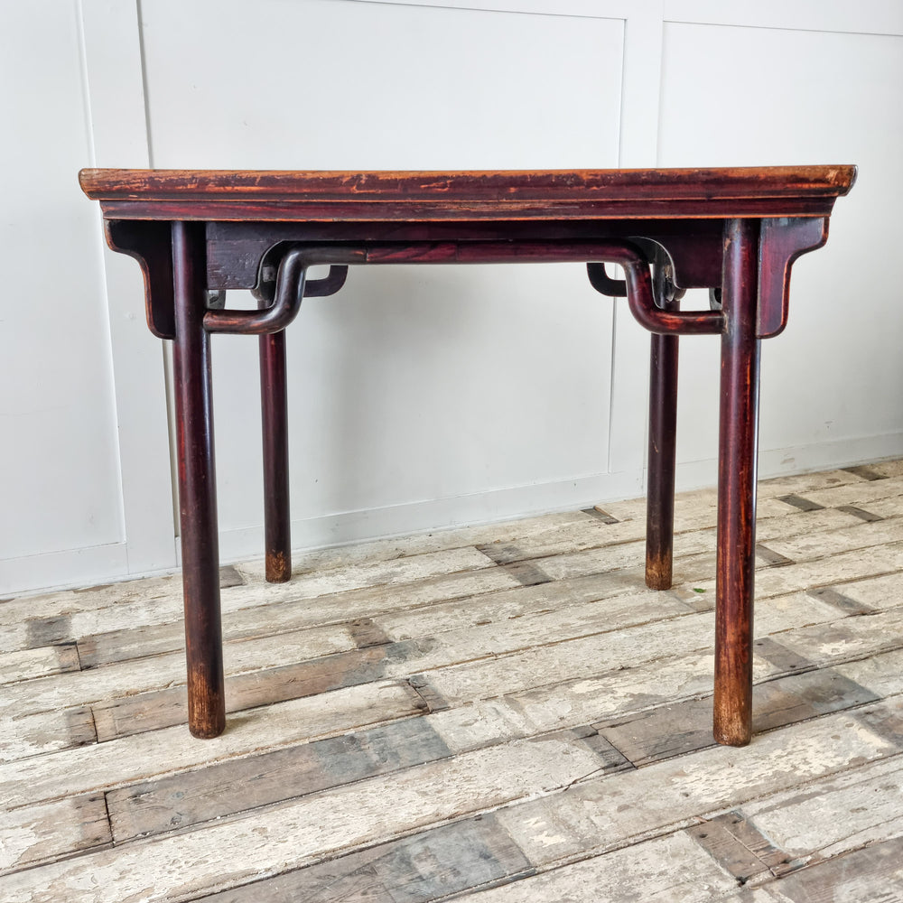 Vintage table featuring decorative spandrels and cylindrical legs