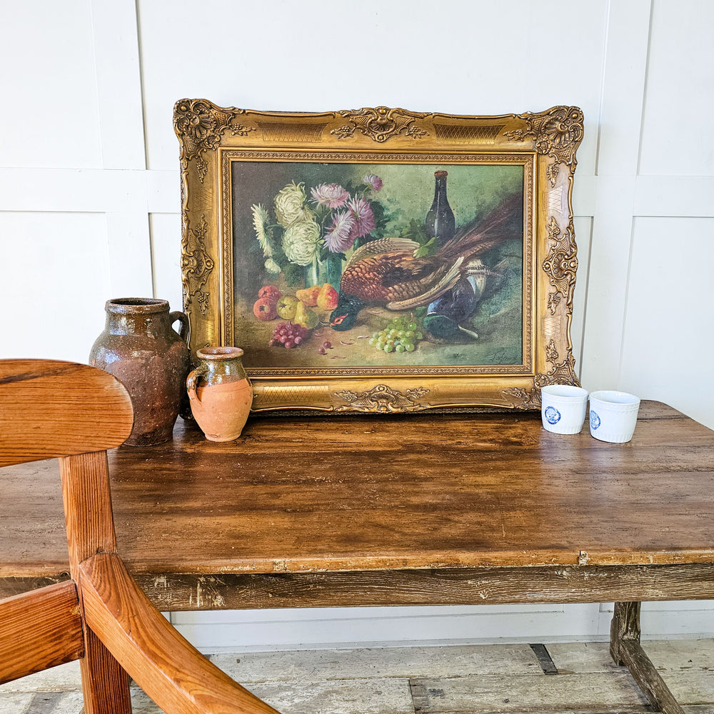 Vintage oil on canvas from 19th Century France, featuring a rich display of game and assorted fruits, enclosed in a decorative gilt frame.