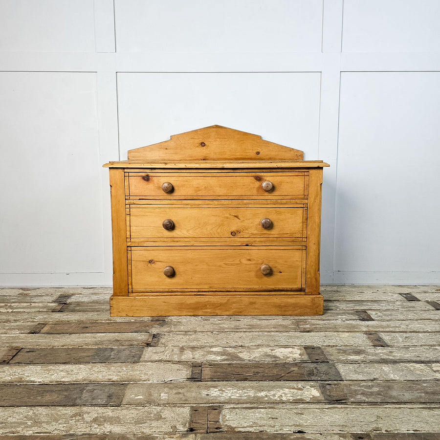Front view of the late Victorian pine chest of drawers with an angular back ledge, offering a sense of the piece's scale and design.