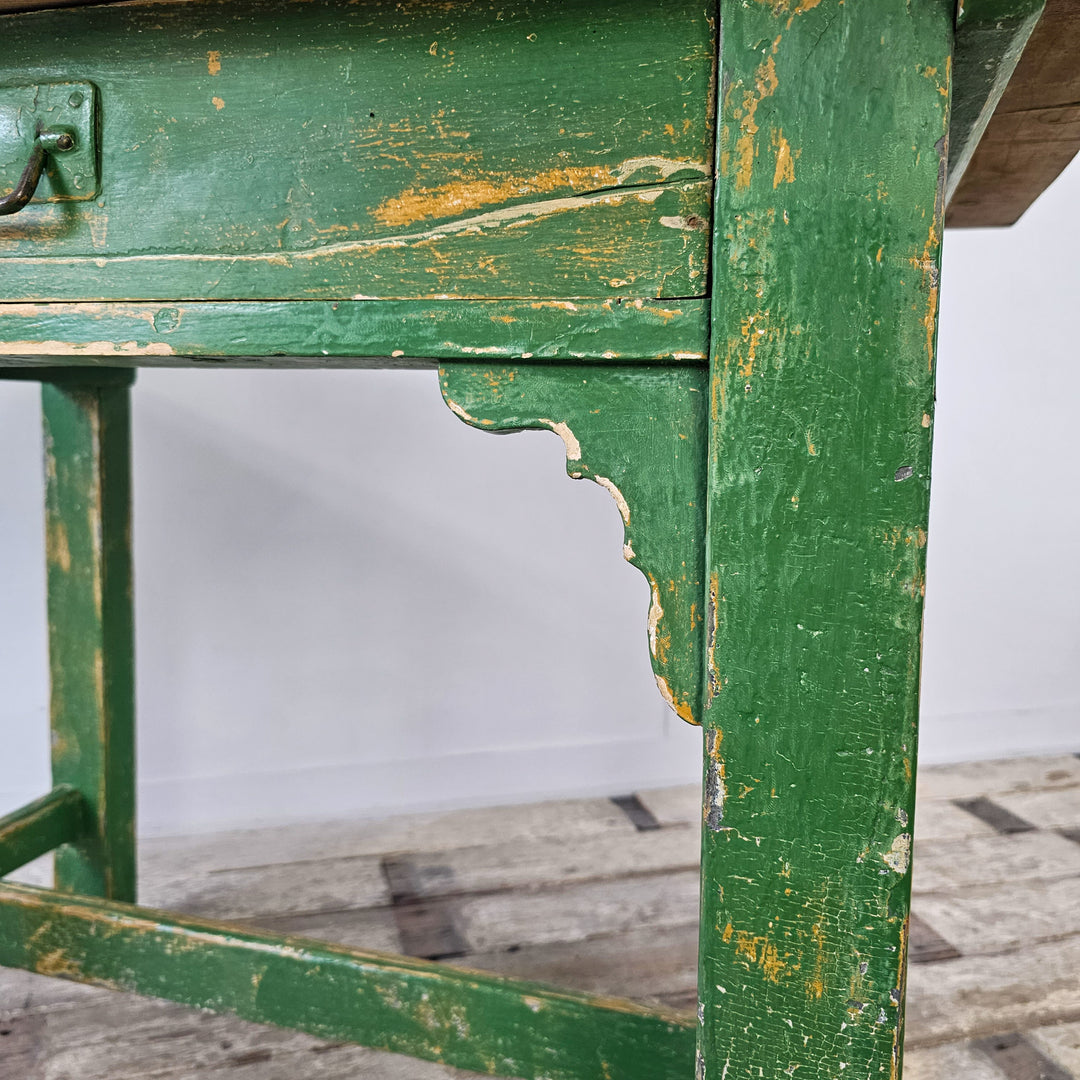 A close up view of the green chippy paint on the base of an antique painted pine prep table