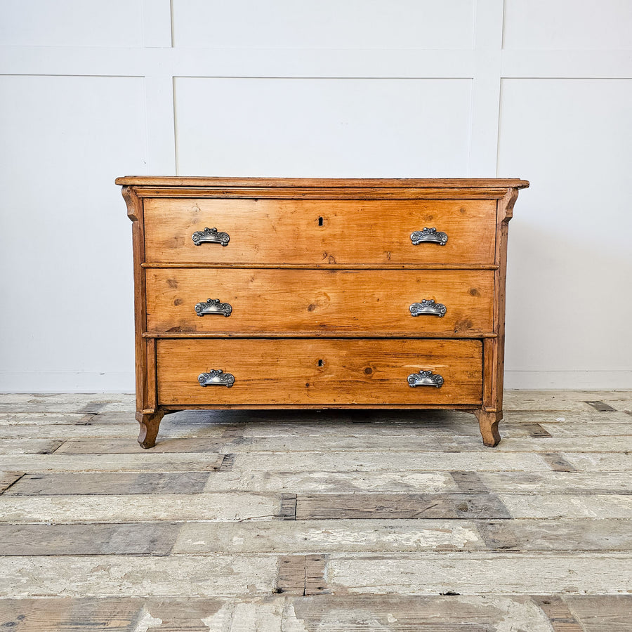 Front view of an antique pine mule chest from early 20th century europe. Featuring lift-top and functional bottom drawer.