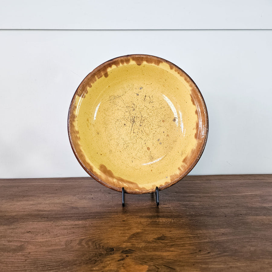Authentic 19th-century stoneware dish by Gustave de Bruyn with glazed yellow center and brown dripped rim.