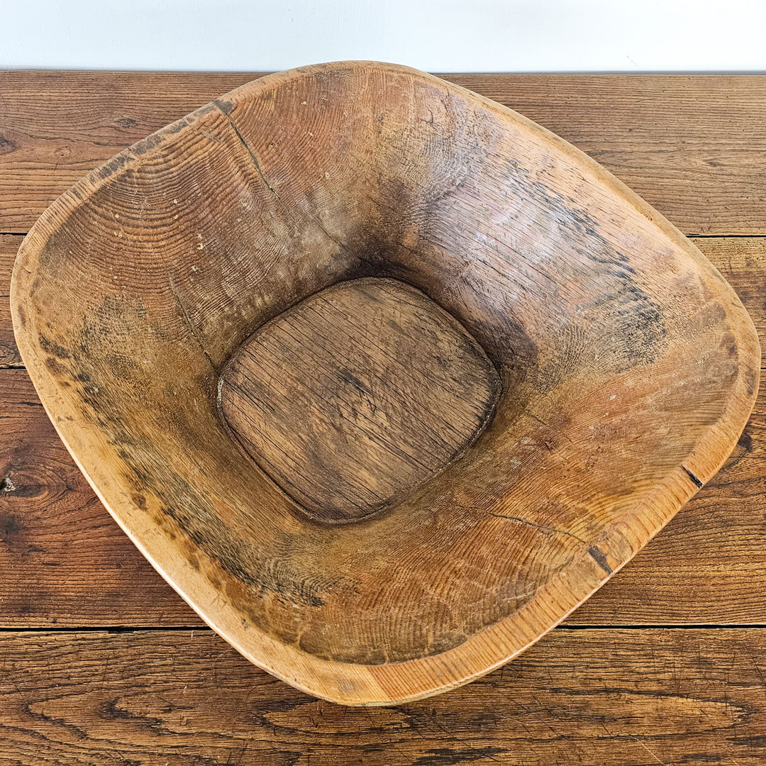 Antique dough bowl with rich patina, perfect for collectors.