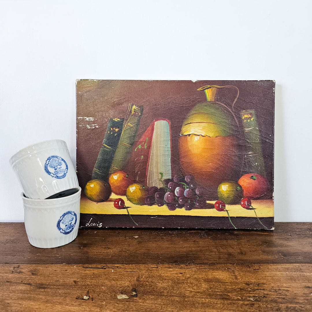 Antique still life artwork with fruit, literature, and a ceramic pitcher, capturing the essence of 19th-century French naïve art.