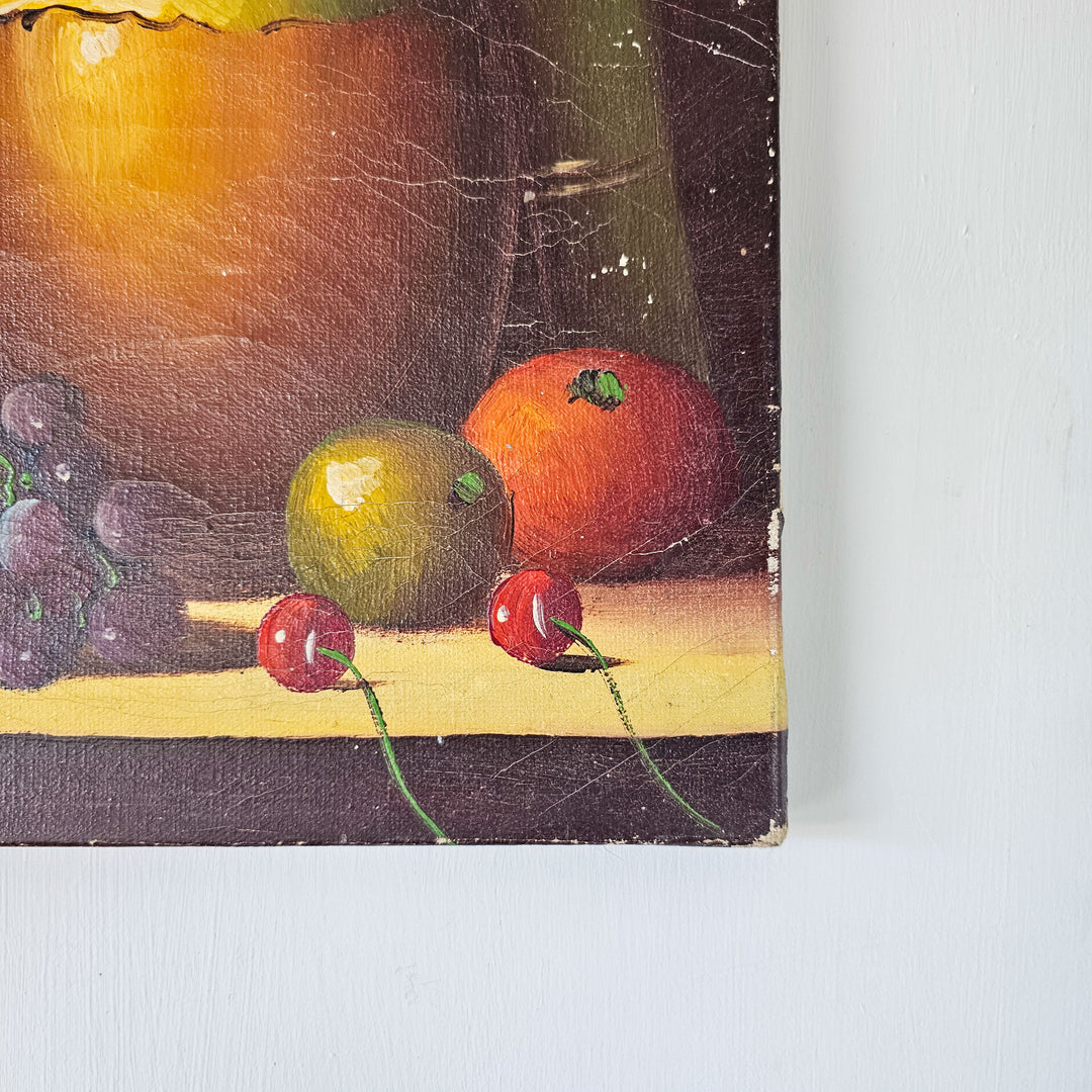 A close view of a classical still life painting, focusing on the lush grapes and ripe fruits beside vintage books.