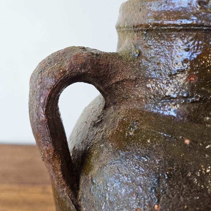 A close up of the glazed handle on an antique Turkish terracotta jar or pot