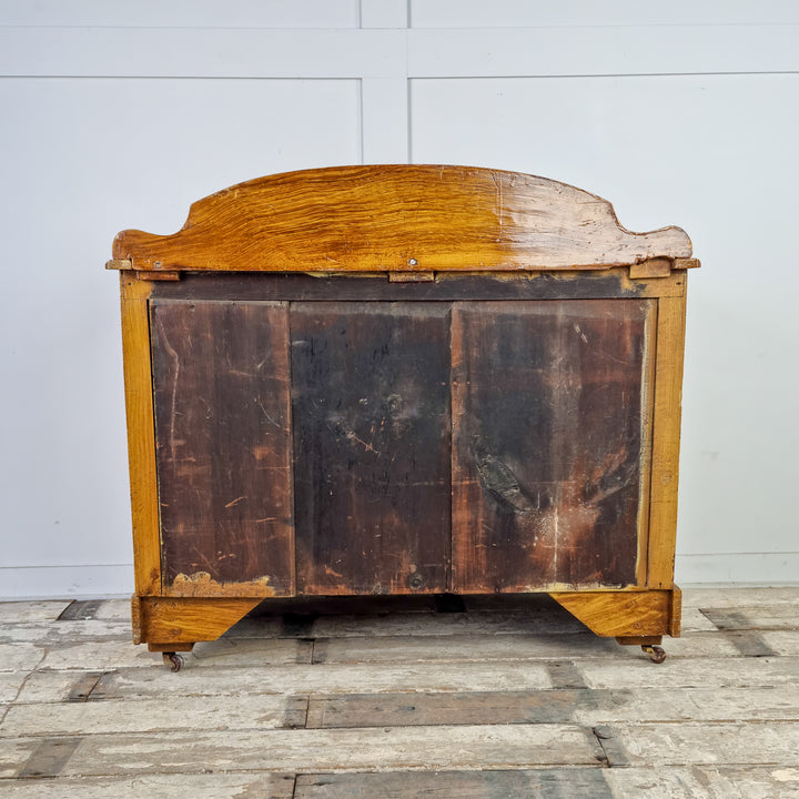 A 19th Century Pine Chest of Drawers with Original Scumble Glaze. The chest features a shaped upstand above a rectangular moulded top and has two short drawers over two long drawers with decorative glass knobs. It is raised on four castors for easy manoeuvrability.