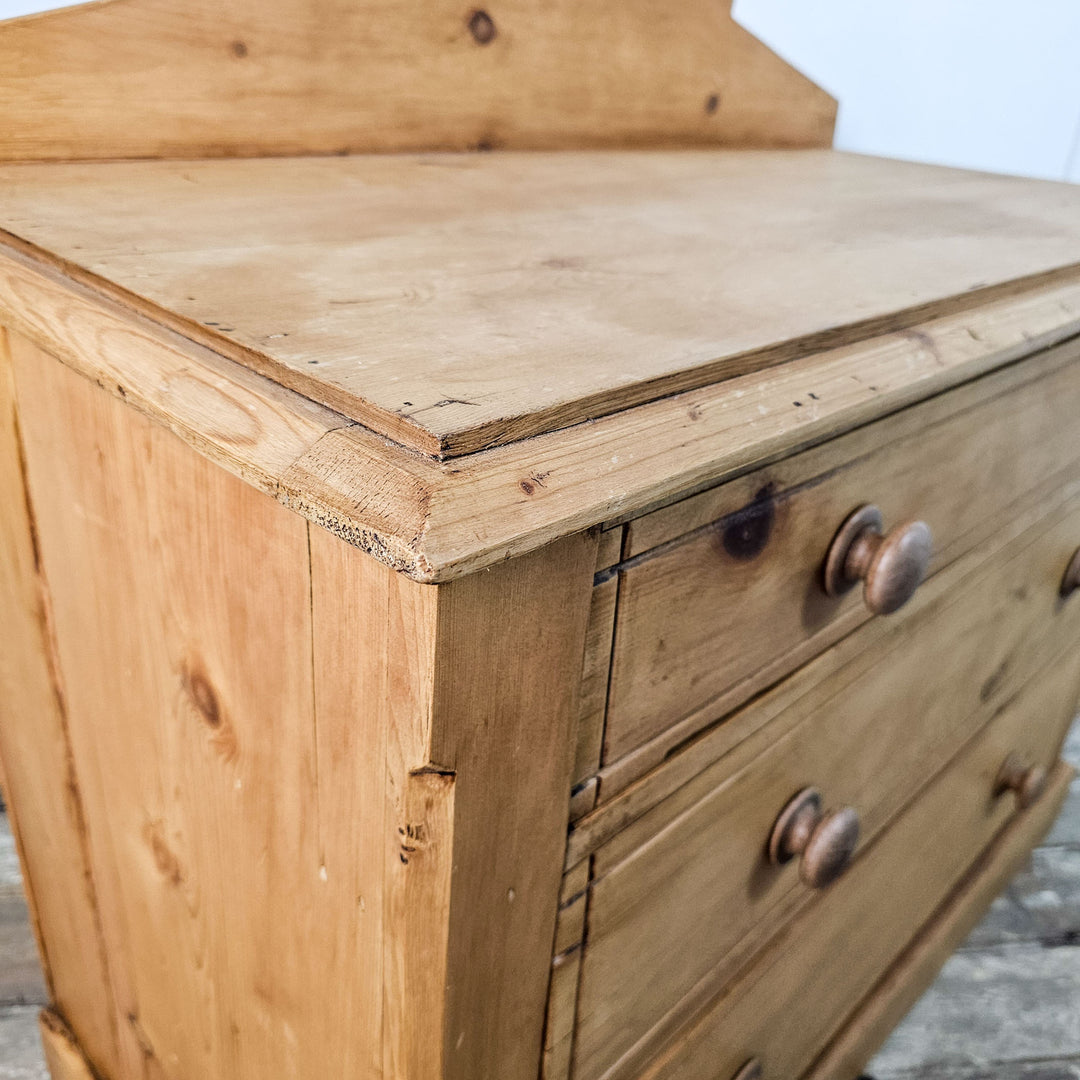 Close view of the chest's top drawer, detailing the pine wood's patina and the corners.