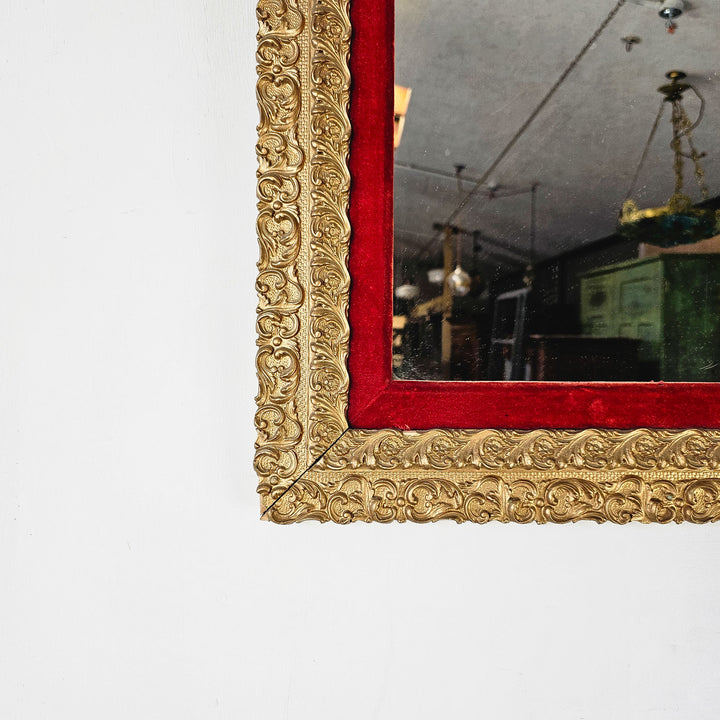 Close-up of the mirror frame, emphasizing the vibrant red velvet surround, adding a lavish touch to this Victorian masterpiece