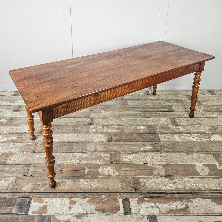 Antique French table with generous planked top and turned legs, suitable for family dining

