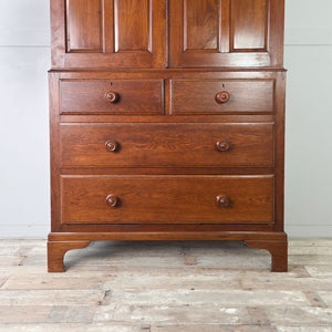 Early 20th century Linen Press in oak with upper cupboard doors, internal shelving and a drawer base raised on bracket feet.