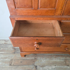 Antique oak Pantry Cupboard with Arts & Crafts Style influence, two panelled doors, internal shelves and a lower two over two drawer layout.