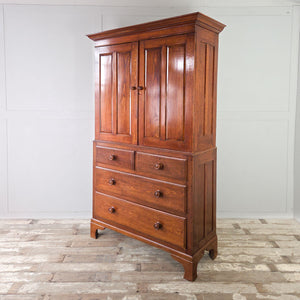 English antique oak Two Part Cupboard with symmetrical design, simple projecting cornice and a drawer base with turned wooden knobs.