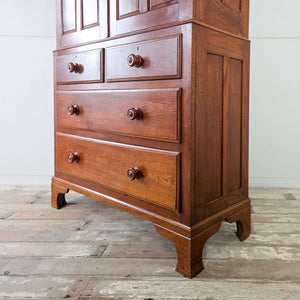 Early 20th century oak Housekeepers Cupboard featuring panelled doors, internal shelving and bracket feet supporting a two over two drawer base.