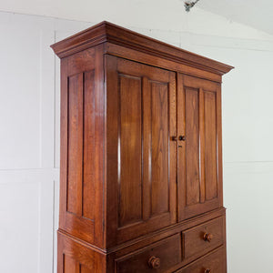 Arts & Crafts Style oak Two Part Cupboard with panelled upper doors, internal shelves and a two over two drawer arrangement below.