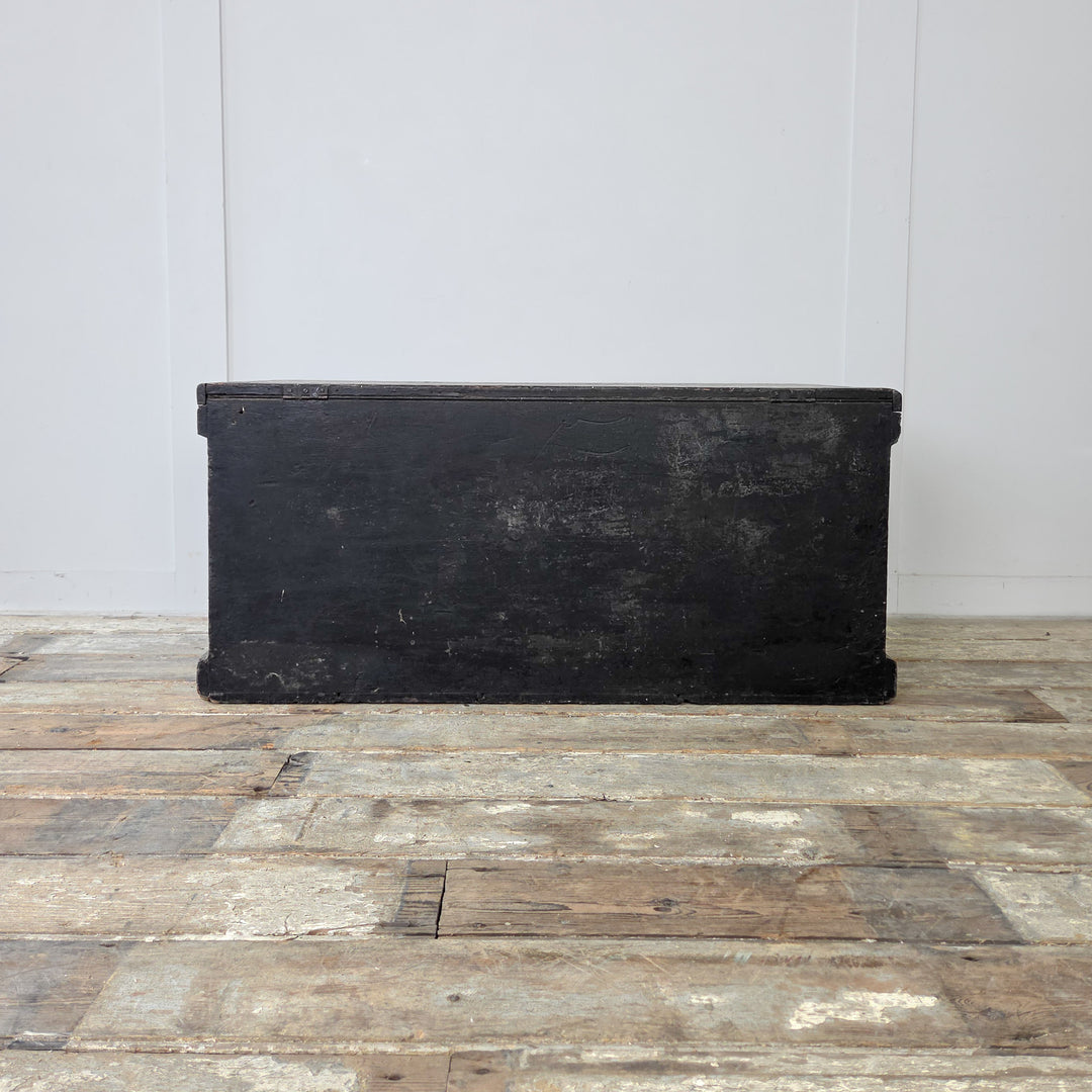 A black painted pine trunk from the Victorian era, ideal for storing blankets, bedding or shoes.