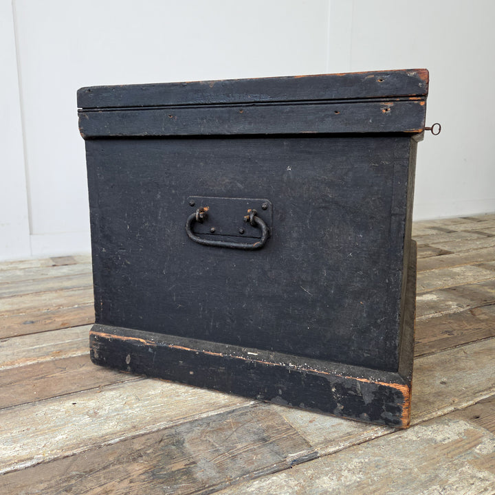 An antique painted pine chest with vibrant internal paper lining and sturdy functional proportions.