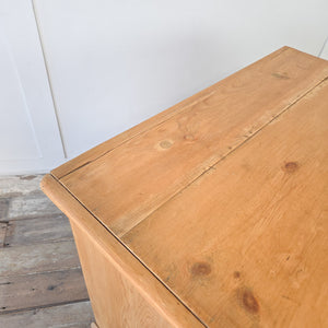 An early 20th century antique pine chest of drawers with three spacious drawers, each fitted with swing handles, raised on a plinth base, finished in honey pine, ideal for farmhouse interiors, period bedrooms, or as a versatile rustic storage chest for hallways and living rooms.