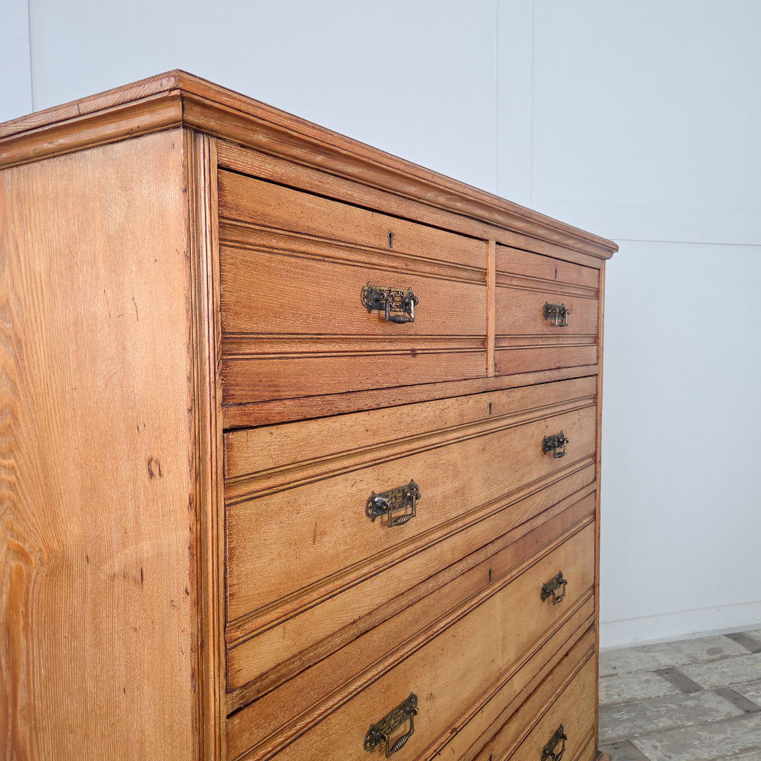 Antique Victorian ash chest with reeded drawer fronts, original brass drop handles, and two short over three graduated drawers above a sturdy plinth base.