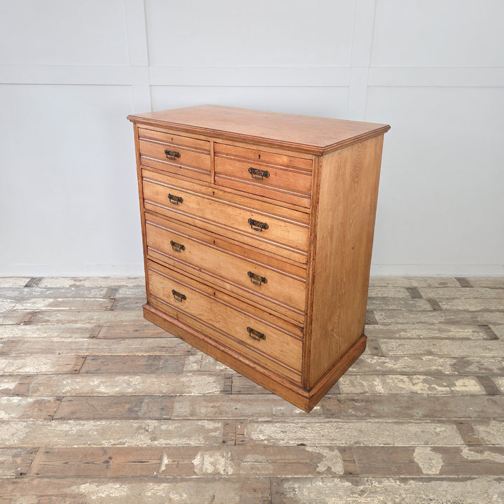 Victorian ash chest of drawers with five drawers, reeded fronts, brass drop handles, golden patina and a plinth base for sturdy support