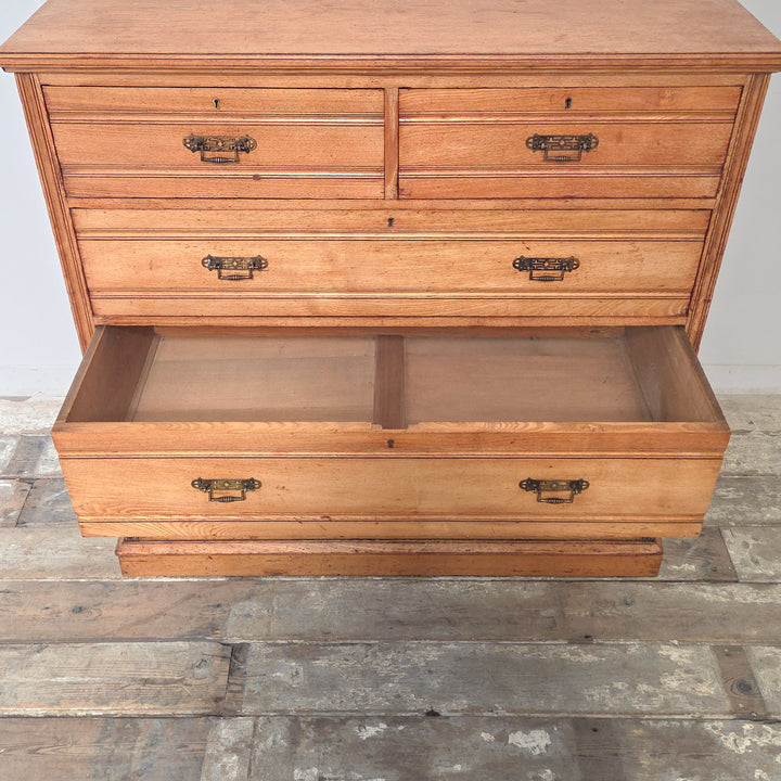 Antique ash chest of drawers, late-Victorian, featuring reeded drawer fronts, brass drop handles, and two over three graduated drawers.