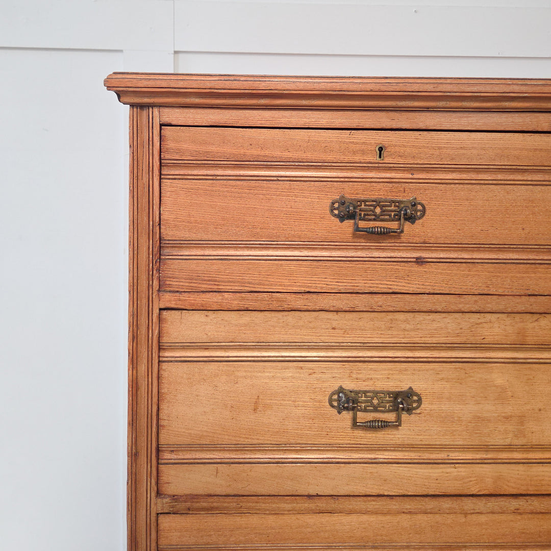Well-made Victorian ash chest with reeded fronts, golden patina, brass drop handles, and a plinth base, ideal for bedroom storage.
