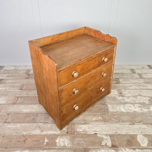 Early 20th century antique ash dresser with three deep drawers that graduate in depth, finished with simple wooden knobs and a gallery-style back.
