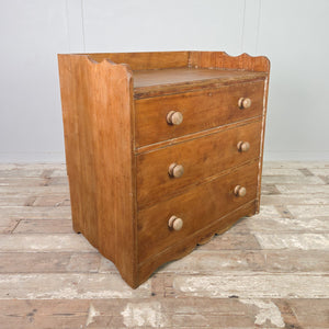 Antique ash storage chest from the early 20th century, featuring three drawers arranged to graduate in depth, a gallery back, and a shaped plinth base.
