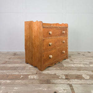 Antique ash bedroom drawers dating from the early 20th century, with three graduated drawers, simple round wooden knobs, and a gallery-style back.
