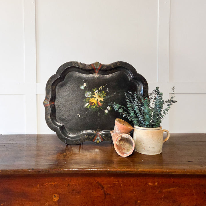 A 19th century papier-mâché tray featuring hand-painted florals and shimmering mother-of-pearl inlay, finished with scalloped edging, suitable for styling on a kitchen dresser, living room mantel or as a tabletop centrepiece.