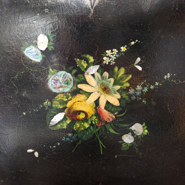 An antique papier-mâché tray from the 19th century with colourful painted florals and iridescent inlay, scalloped edging and scrolling foliage, perfect for display on a sideboard or as a hanging wall tray in a sitting room.