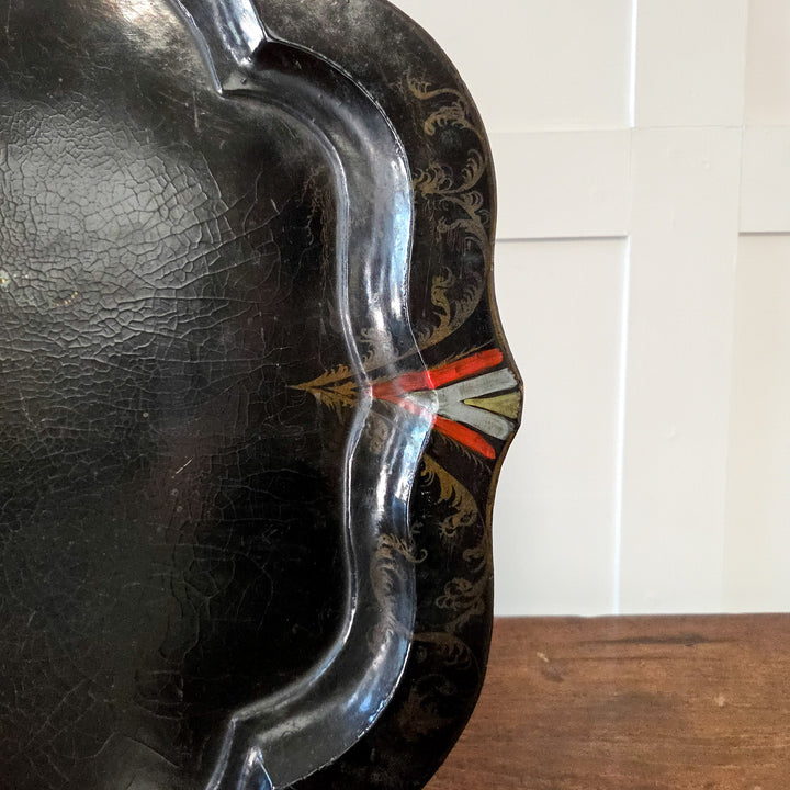 A Victorian black lacquer serving tray with painted flowers and mother-of-pearl inlay, suitable for use as an ornamental tray on a hall console or mounted above a fireplace as a decorative wall accent.