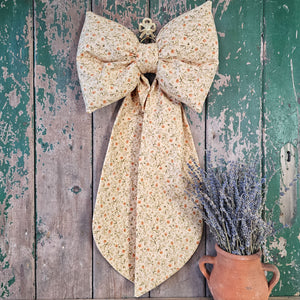 Handmade bow in warm cream floral fabric
