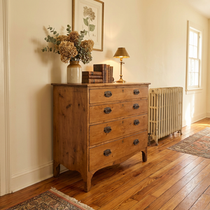 An early 19th-century Georgian pine chest of drawers featuring five drawers arranged two over three, fitted with oval brass pull handles and shaped bracket feet. A beautiful example of antique Georgian furniture, perfect for country house interiors or farmhouse bedrooms.