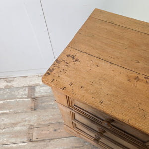A rustic pine and ash four-drawer chest dating to the early 19th century, featuring round wooden knobs, original ivory escutcheons and shaped bracket feet. The panelled sides and simple lines suit a range of household storage needs.