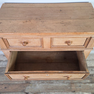 A cottage style early 19th-century chest of drawers made from pine and ash with panelled sides and decorative bracket feet. The four drawers, fitted with round knobs and original ivory escutcheons, offer versatile storage.