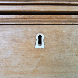 A four-drawer early 19th-century chest of drawers in pine and ash with original ivory escutcheons, round knobs and panelled sides. The shaped bracket-style feet lift the piece and add a straightforward country house style finish.