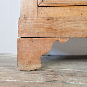 A cottage style early 19th-century four-drawer chest made from pine and ash with simple lines and neatly panelled sides. Round wooden knobs and original ivory escutcheons complete this practical set of bedroom drawers.