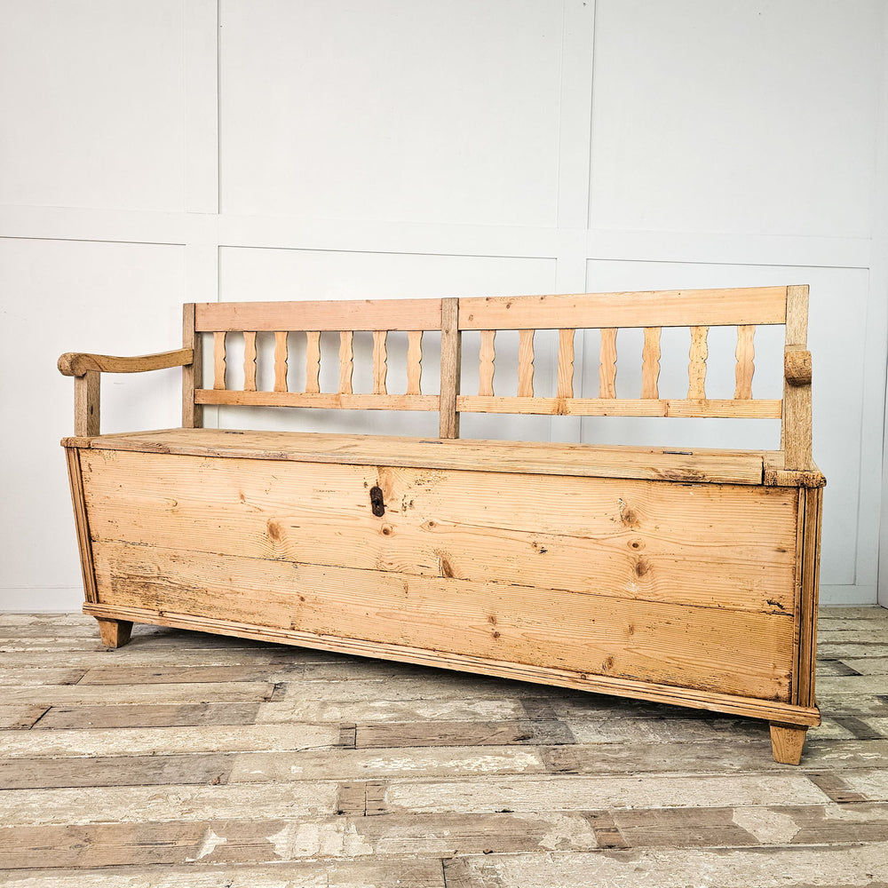 Antique furniture: pine box settle with vertical slats.