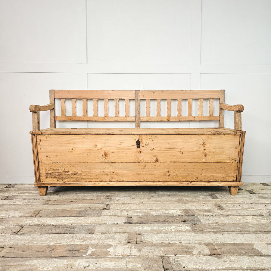 Vintage pine box settle with hinged seat for storage.