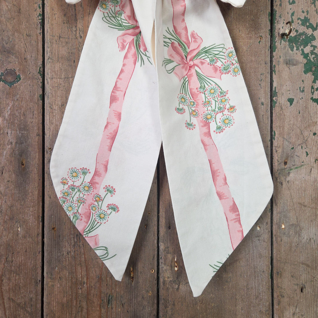 A handmade fabric bow created from Sanderson’s 1986 “Daisy Stripe” vintage fabric, featuring tapering tails, padded structure and brass hanging hoop. A farmhouse style decorative bow that reflects the craftsmanship of traditional English textiles.