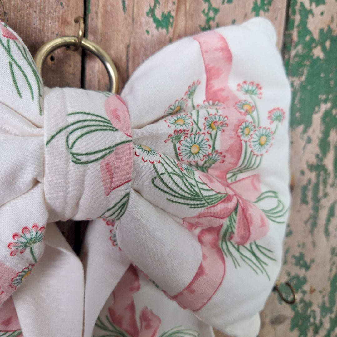 Large handmade bow crafted from original Sanderson “Daisy Stripe” vintage fabric dating to 1986. Lightly padded and structured for shape, with long flowing tails and a brass hanging hoop, a cottage style bow made in limited numbers.