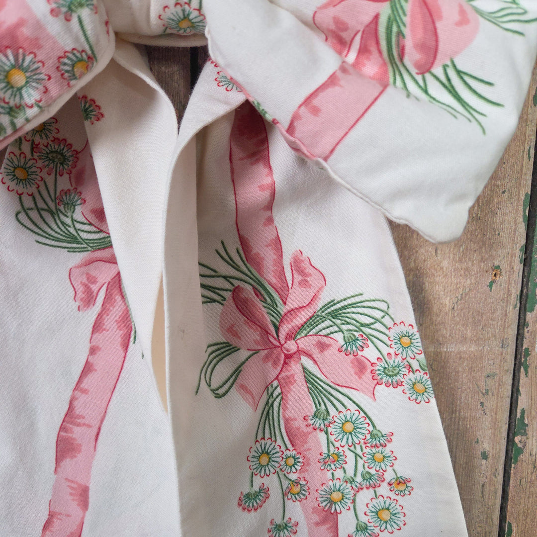 A large decorative handmade bow crafted from Sanderson “Daisy Stripe” fabric first produced in 1986. Padded and structured for fullness with long tapering tails and a brass hanging hoop, a cottage style bow made from vintage English material.