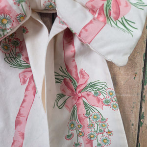 A large decorative handmade bow crafted from Sanderson “Daisy Stripe” fabric first produced in 1986. Padded and structured for fullness with long tapering tails and a brass hanging hoop, a cottage style bow made from vintage English material.