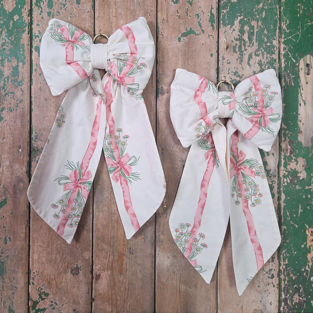 Handmade decorative fabric bow made using authentic vintage 1986 Sanderson “Daisy Stripe” cotton. Structured and padded for fullness with long tails and an antiqued brass hoop, a large cottage style bow with distinctive English vintage character.