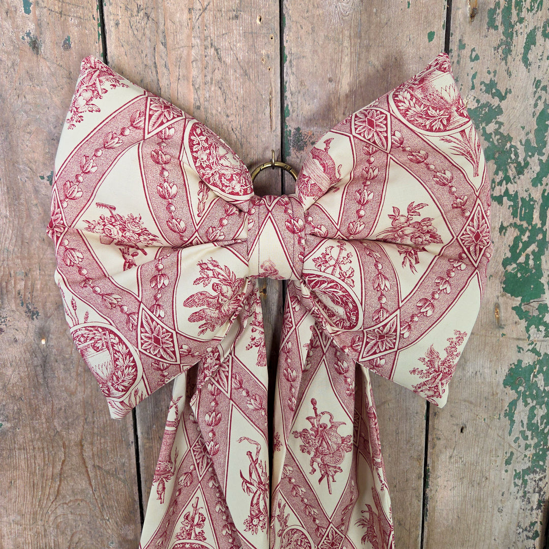 Country House Bow handmade from authentic vintage textiles. Designed with padded structure, tapered tails, and brass hanging hoop, it’s a decorative accent for farmhouse interiors and period homes, perfect on doors, wardrobes, or shelves.