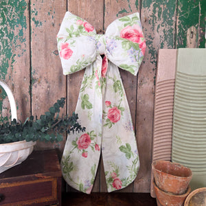Handmade vintage fabric bow from Jennings & Cox, part of the Country House collection. Created in Sanderson Roses & Lilacs fabric with pastel floral motifs, padded with long tails and brass ring, limited to just three examples.