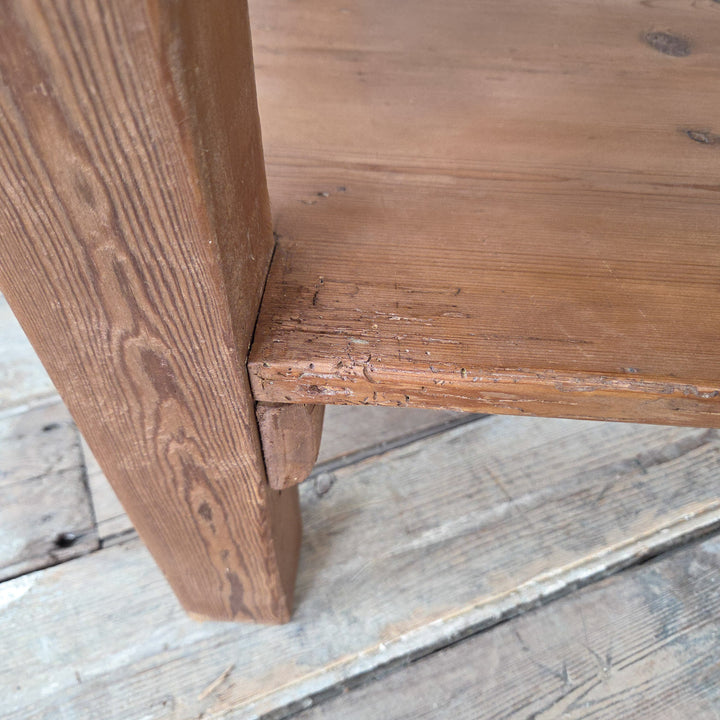 A rustic Victorian pine farmhouse prep table dating to the 19th century with planked top, twin drawers and shaped lower shelf. Raised on sturdy legs, this antique pine table can be used in the kitchen as a prep or serving surface, in the hallway as a console table, or in a dining room as a farmhouse sideboard. An authentic Victorian piece that combines useful storage with simple, practical design.
