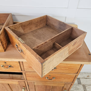 A country house style dresser base in 19th-century pine with seven drawers and three cupboards. Matching brass handles and a lighter scrubbed top make it a practical sideboard for storing cookware, linens or household items.