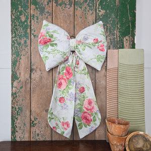 A handmade vintage fabric bow from Jennings & Cox, made in Sanderson Roses & Lilacs design. Each bow has a padded body and long tails, finished with brass ring, created in very limited numbers as part of the Country House Bow collection.